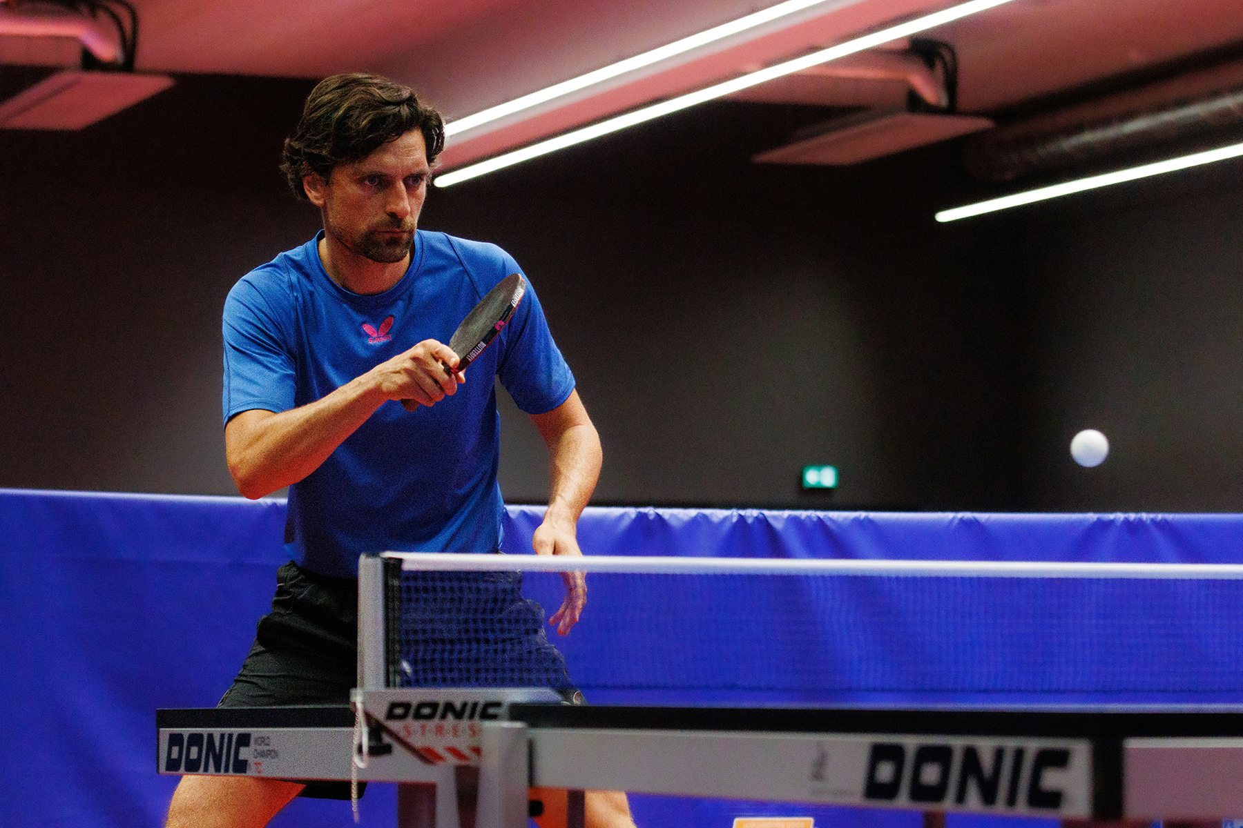 A man is playing ping pong